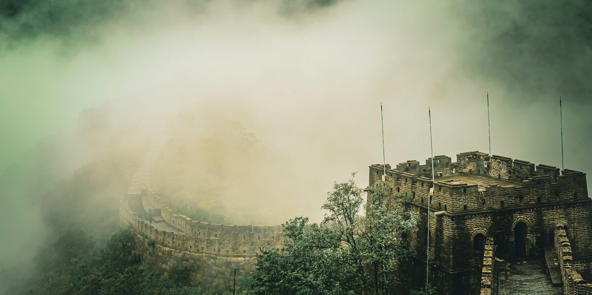 A long stone wall disappearing into mist